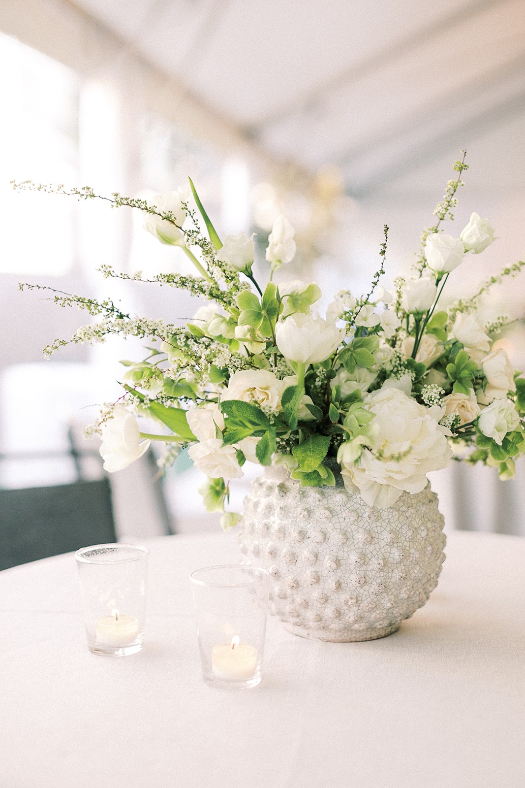 White wedding flowers in round ceramic vase
