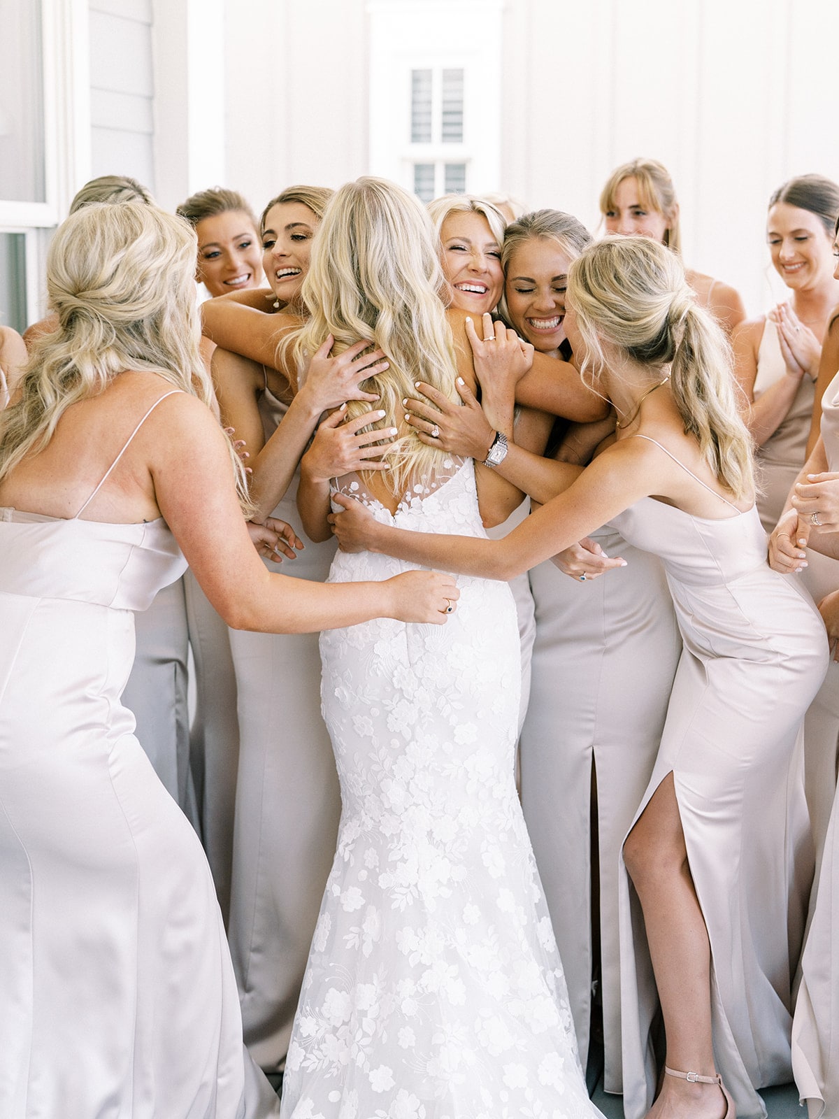 Bride hugged by bridesmaids