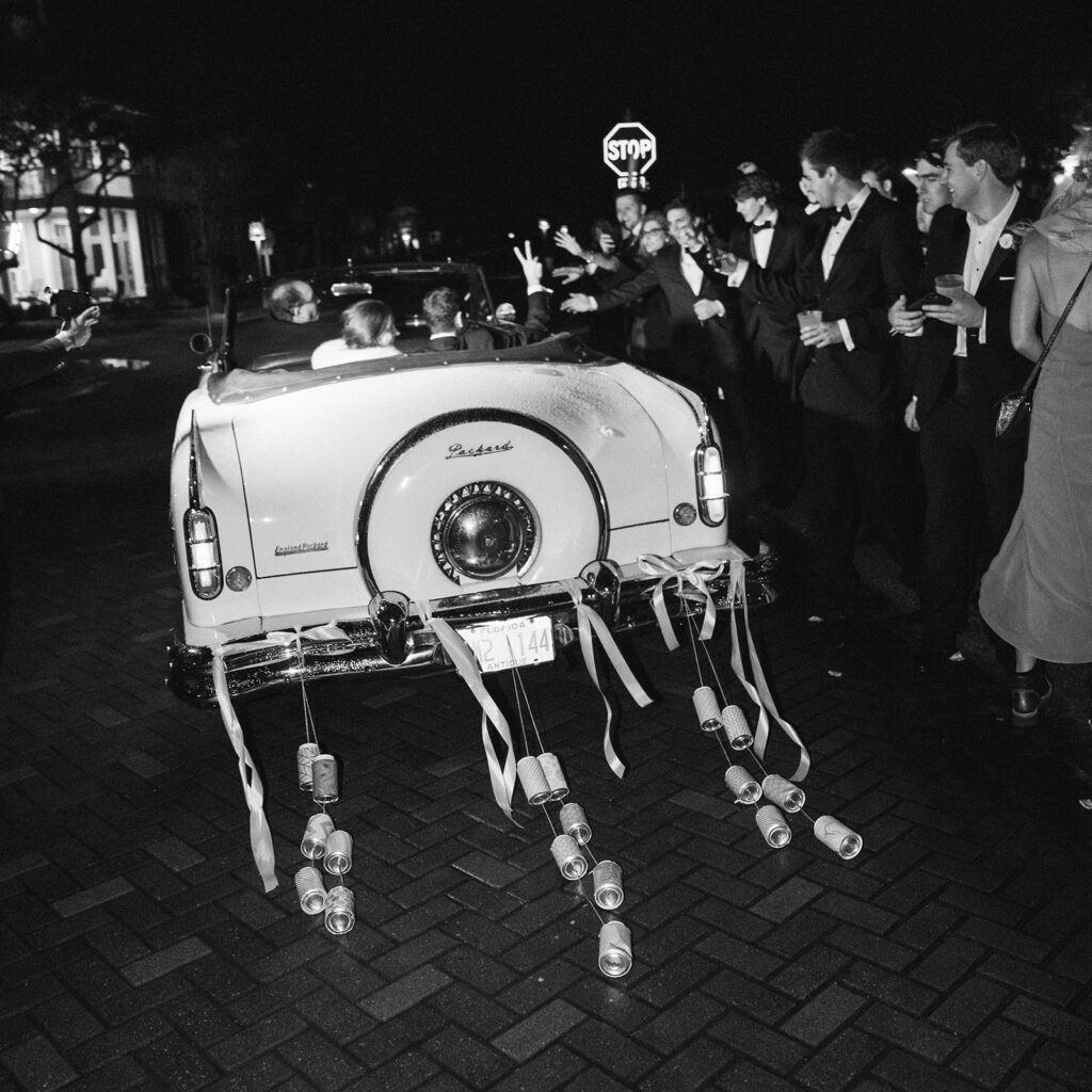 Vintage car with can atatched for wedding exit