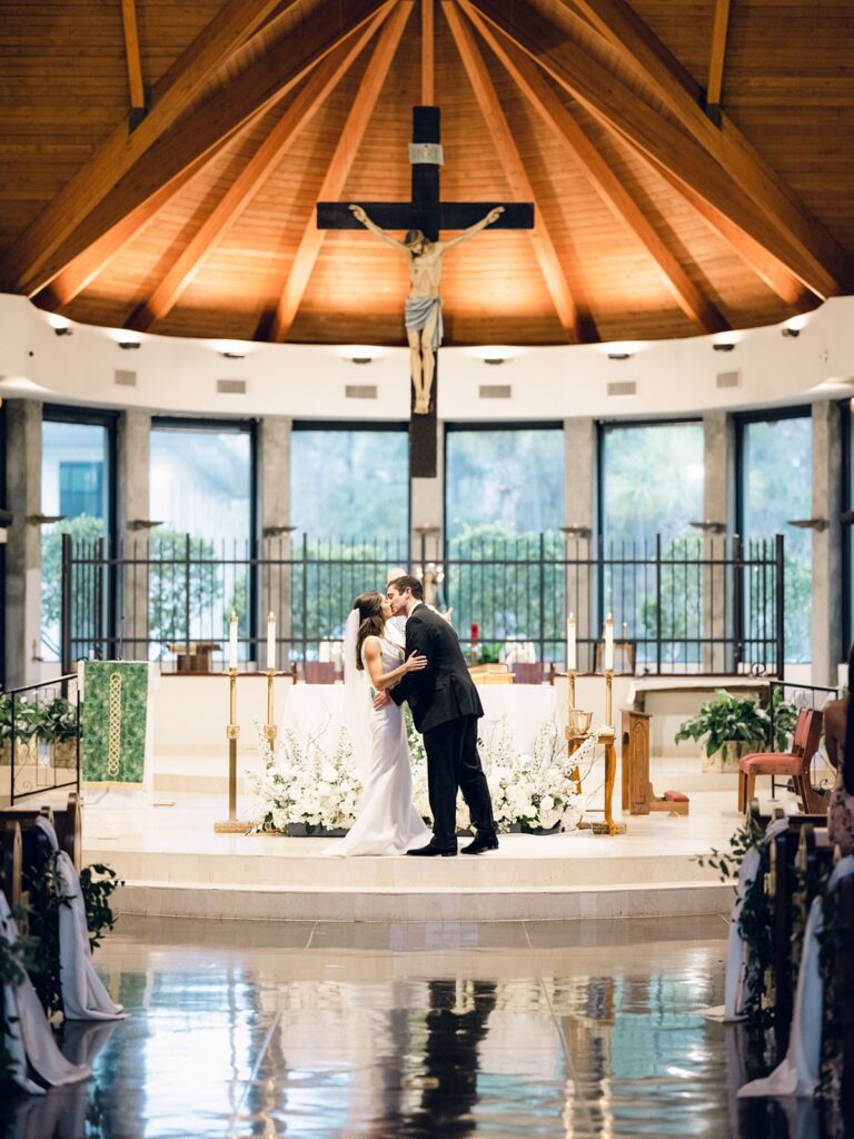 Bride and groom kissing in catholic church