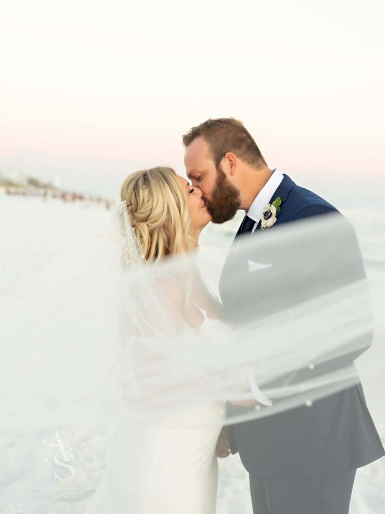 Bride and groom kissing on a beach