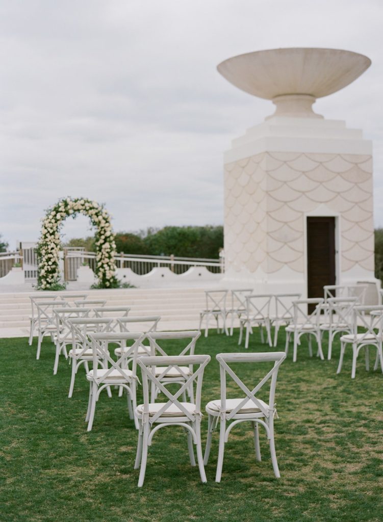 White wood chairs at outdoor wedding ceremony