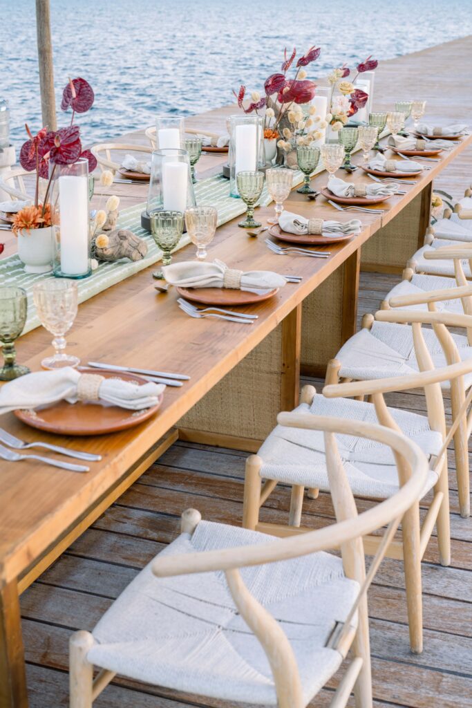 wood table with wood and linen chairs set with green table runner