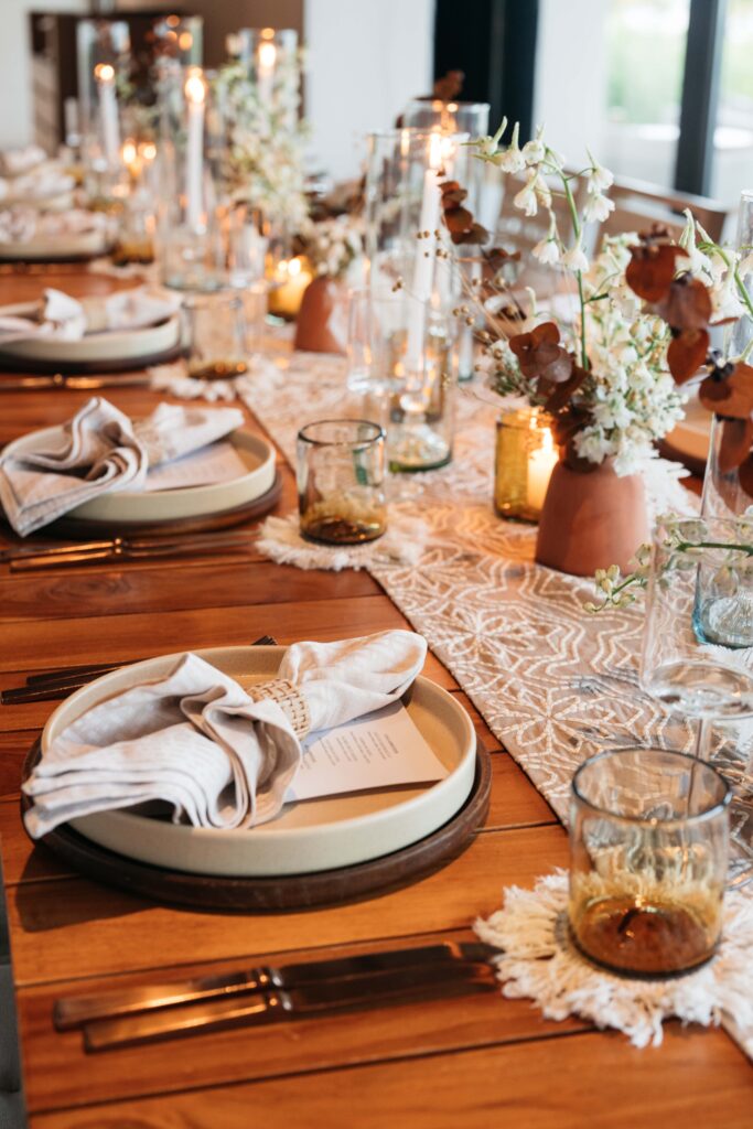 Wood table with table runner and flowers in terra cotta vases 